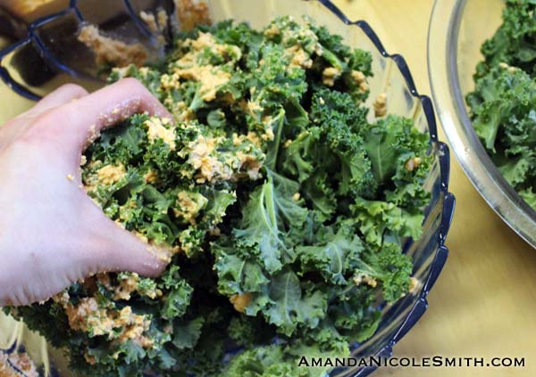 Smothering kale chips with raw vegan cashew cheese